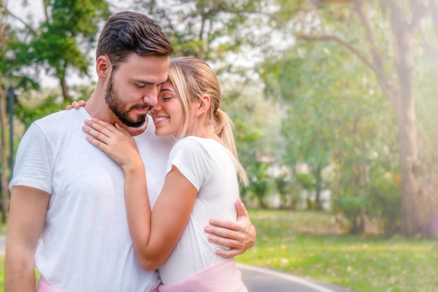 Jeune couple s'embrassant contre les arbres