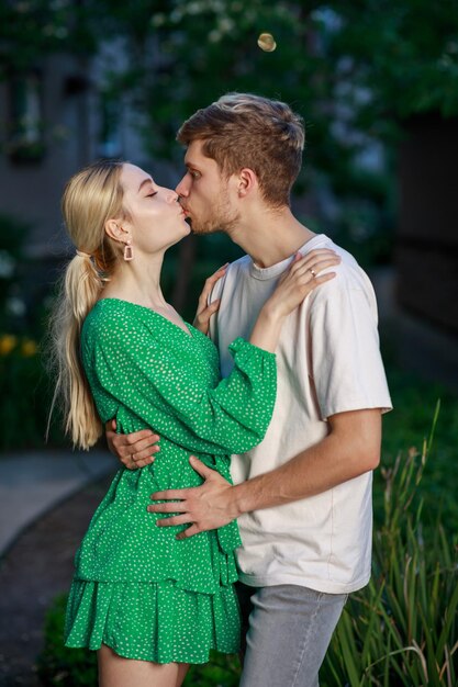 Un jeune couple s'embrassant dans la rue la nuit