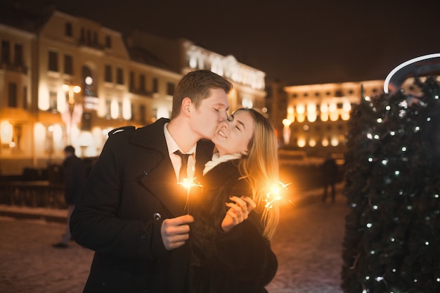 Jeune couple s&#39;embrassant dans la ville avec fond de bokeh. Concept de la Saint-Valentin