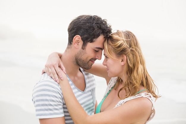 Jeune couple s'embrassant sur la plage