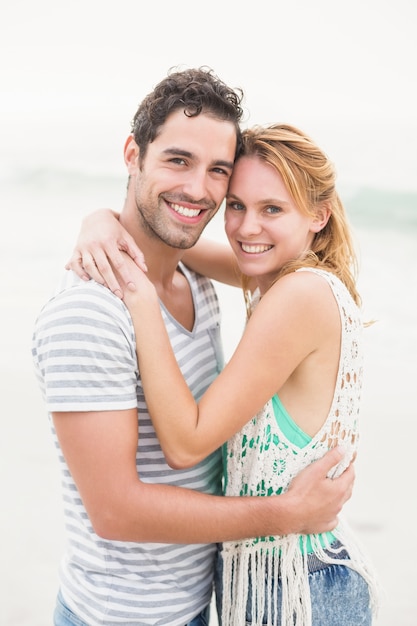 Jeune couple s'embrassant sur la plage