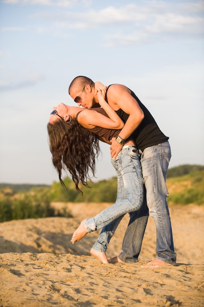 Jeune couple s'embrassant sur une plage