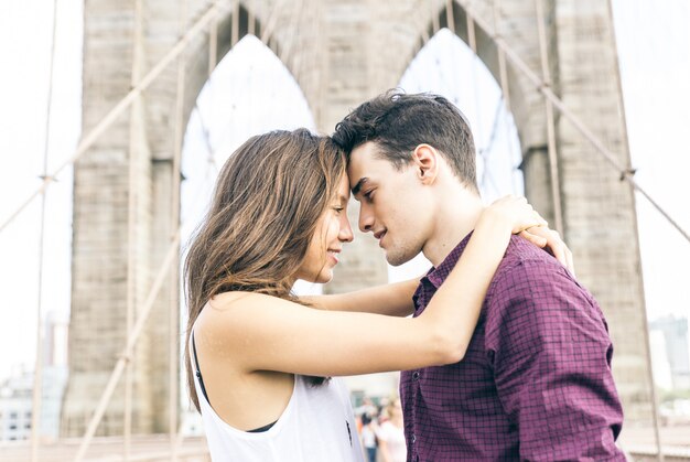 Jeune couple s'embrassant sur le pont de Brooklyn