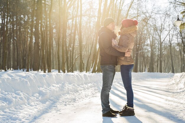 Jeune couple s'embrassant et s'embrassant dans le parc en hiver.