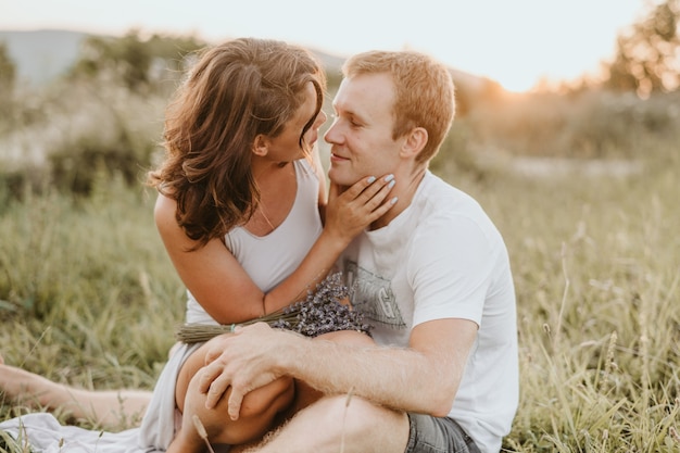 Jeune couple s'embrassant et s'embrassant à l'extérieur en été.