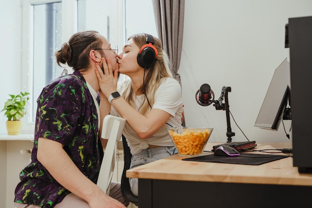 Jeune couple s'embrassant sur la table avec un ordinateur personnel de jeu