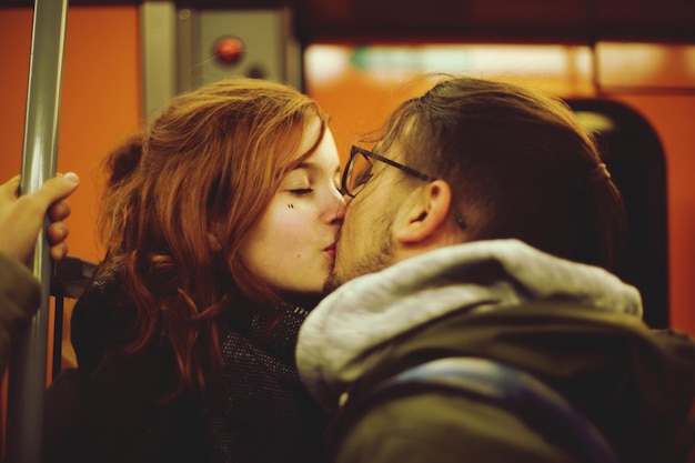 Un jeune couple s'embrasse dans le train.