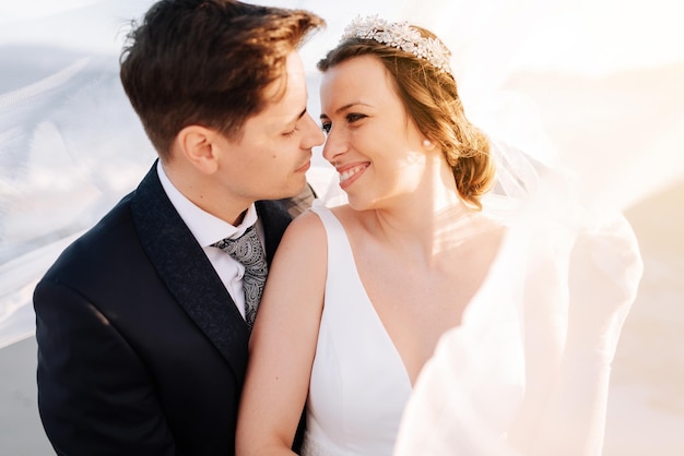 Un jeune couple s'embrasse à l'extérieur.