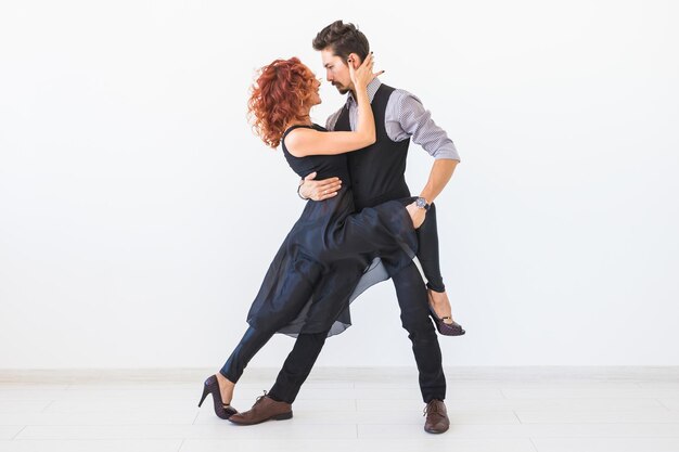 Photo un jeune couple s'embrasse sur un fond blanc.