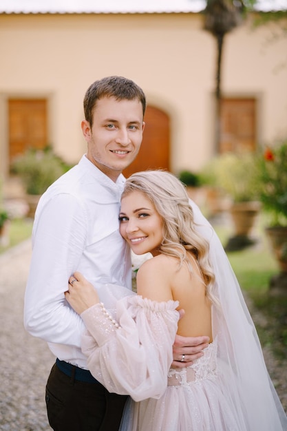 Un jeune couple s'embrasse et regarde la caméra mariage à florence en italie dans une ancienne villa