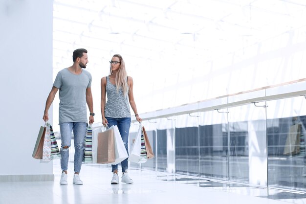 Jeune couple avec des sacs à provisions discutant de quelque chose photo avec espace de copie