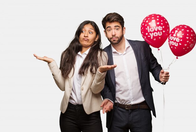 Jeune couple en Saint Valentin doutant et haussant les épaules