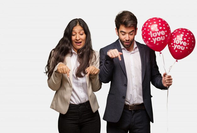 Jeune couple en Saint Valentin pointant vers le bas