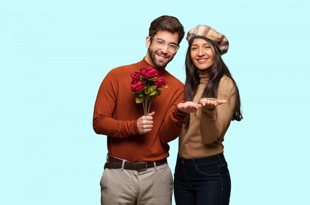 Jeune couple en Saint Valentin tenant quelque chose avec les mains