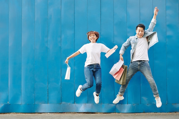 Jeune couple, sauter, à, sacs provisions