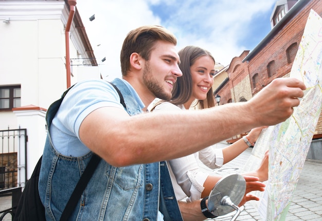 Photo jeune couple avec scooter en regardant la carte.