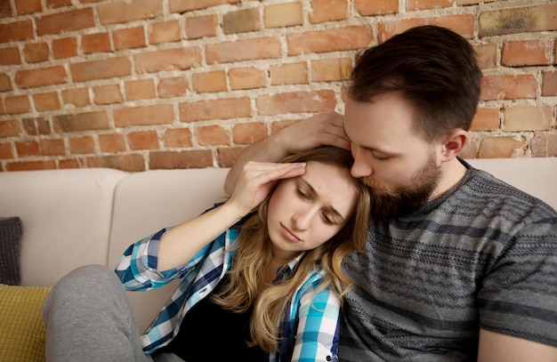 Un jeune couple se détend sur le canapé à la maison.