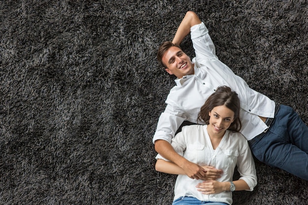 Jeune couple se détendre sur le tapis