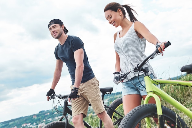 Jeune couple se reposant après une balade à vélo dans le champ close up