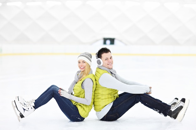 un jeune couple se reposant sur une patinoire