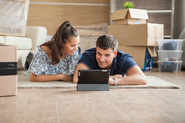 Jeune couple se sentant amusé dans leur nouvelle maison. Couple parlant de nouveaux départs