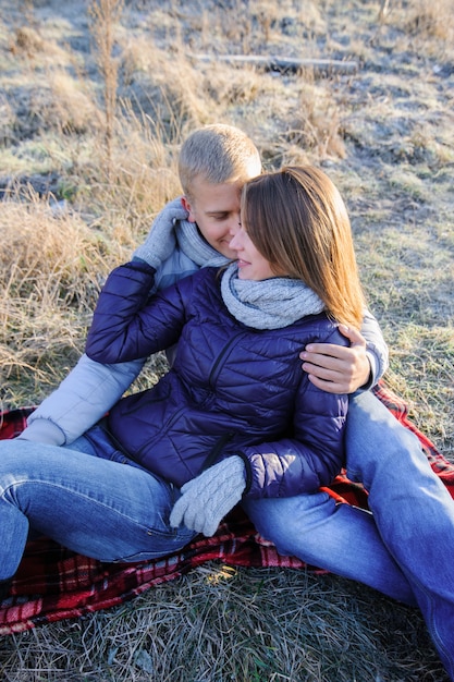 Jeune couple sensuel jolie mode amoureux assis dans un champ froid d'hiver