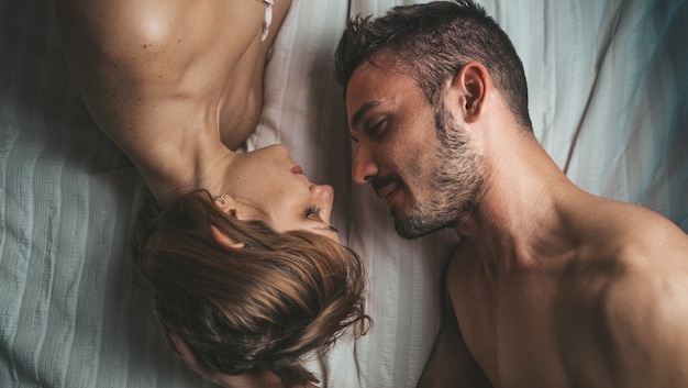 Jeune couple sensuel et romantique dans le lit