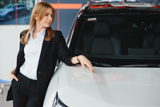 Jeune couple souriant au showroom automobile