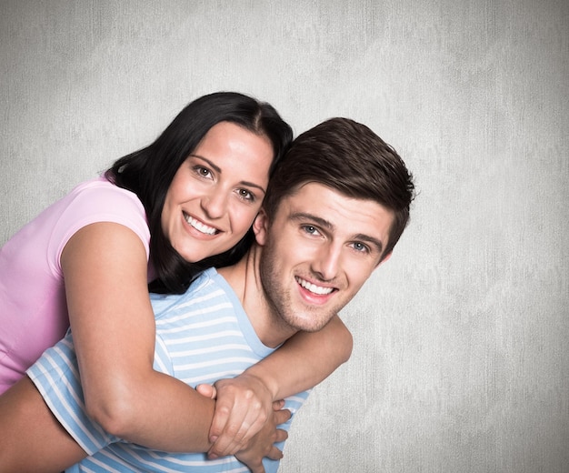 Jeune couple souriant à la caméra contre une surface altérée