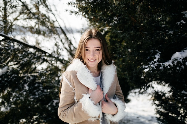 Jeune couple sourire et s&#39;embrasser dans le parc en hiver