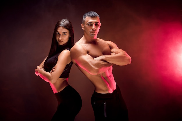 Jeune couple sportif sur mur noir