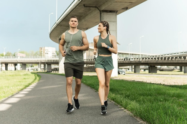 Jeune couple sportif pendant l'entraînement de jogging dans la rue de la ville