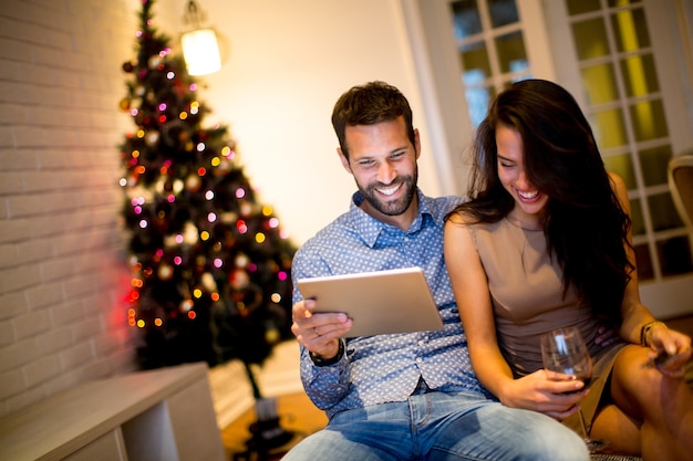 Jeune couple avec tablette au réveillon