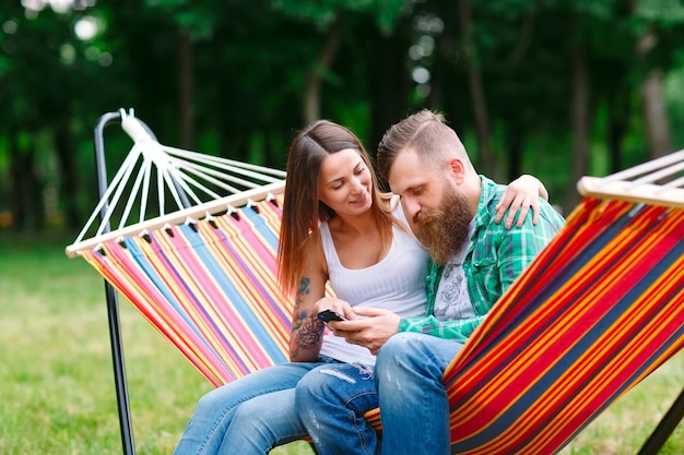 Jeune couple, à, téléphone portable, reposer hamac
