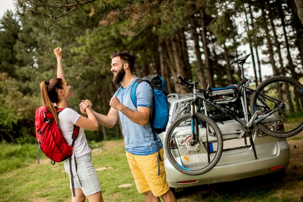 Jeune couple avec tenue de trekking debout dans la forêt