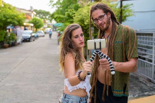 Jeune couple de touristes hispaniques ensemble dans les rues à l'extérieur