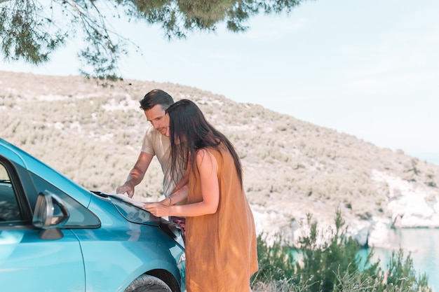 Jeune couple touristique avec carte voyageant en voiture