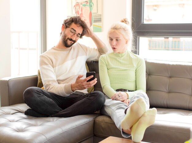 Jeune couple utilisant un smartphone à la maison