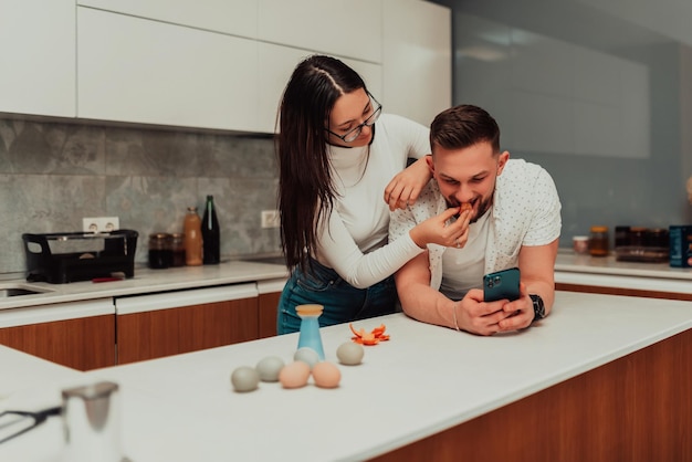 Un jeune couple utilisant un smartphone en pensant à quoi cuisiner