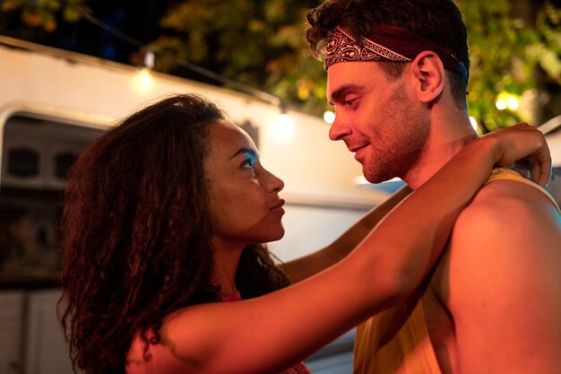 Jeune couple en vacances avec le camping-car. Danser en plein air la nuit. Concept sur les voyages en voiture et le mode de vie en vacances