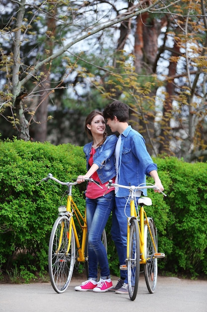 Jeune couple avec des vélos dans le parc