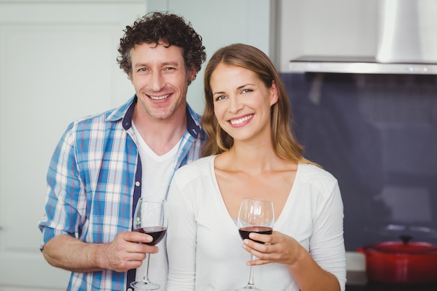 Jeune couple avec un verre de vin à la maison