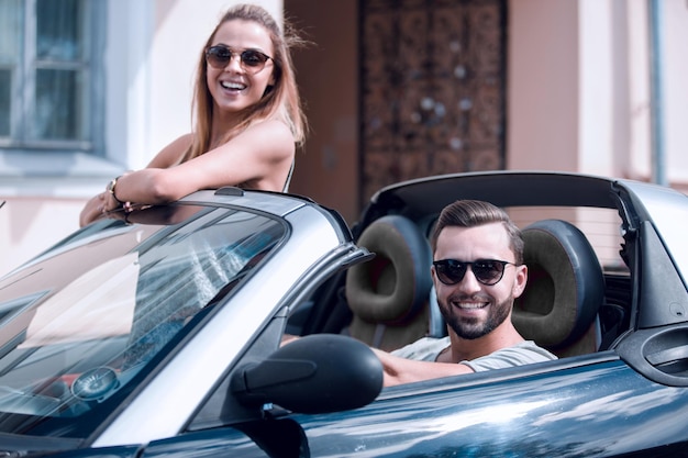 Photo jeune couple en voiture décapotable