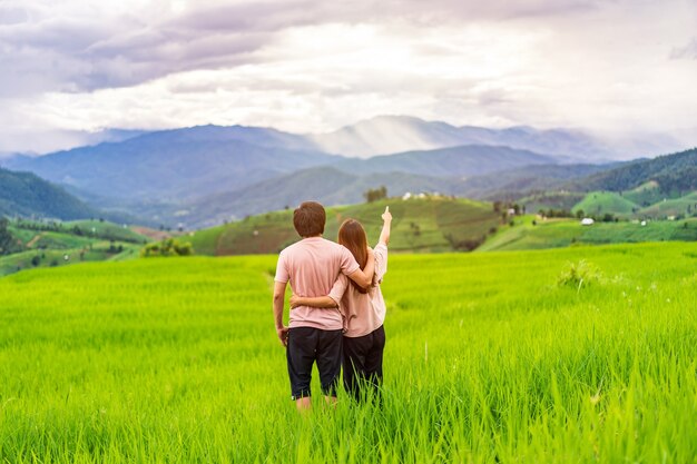 Jeune couple voyageur en vacances appréciant et regardant de belles rizières vertes sur le terrain en Thaïlande