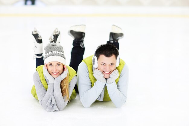 Photo un jeune coupleresting sur une patinoire