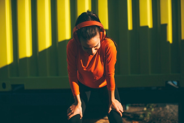 Jeune coureur féminin attrayant prenant une pause après le jogging en plein air