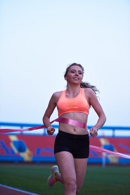jeune coureur femme sportive se détendre et s'étirer sur une piste de course athlétique