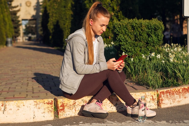 Jeune coureuse, athlète fait du jogging dans la rue de la ville au soleil.