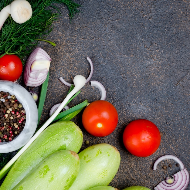 Jeune courgette, tomates, herbes et épices au printemps sur fond noir