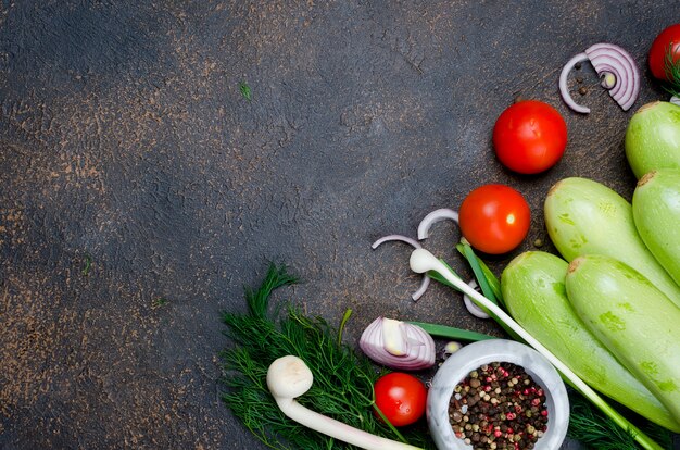 Jeune courgette, tomates, herbes et épices printanière sur fond noir